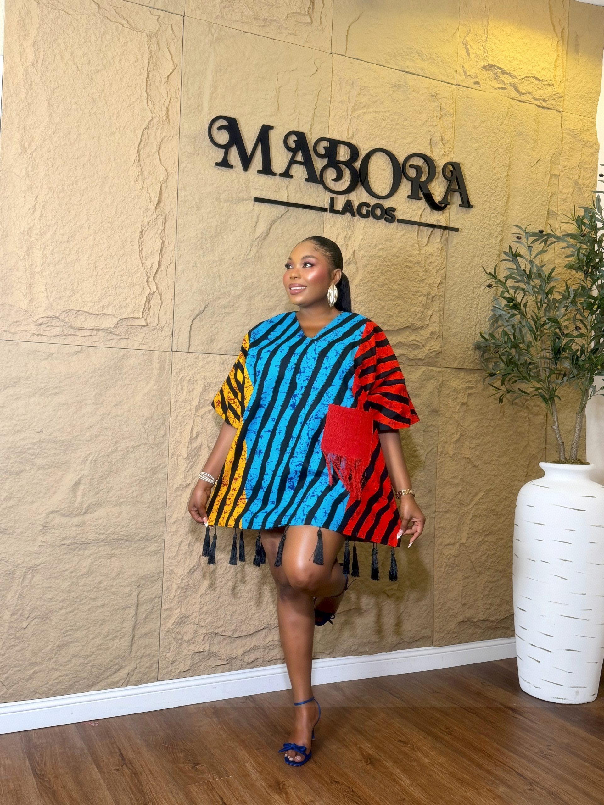 Model wearing Tassels Bubu vibrant multi-color ready-to-wear short dress with fringe pocket and tassel hem.