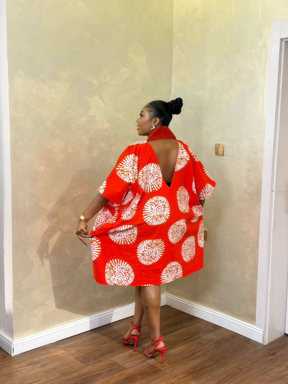 Woman wearing a red and white Short Eko Bubu with open-back detail