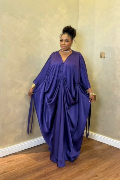 Woman wearing a flowing purple satin bubu dress