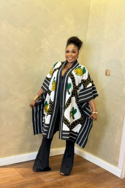 Black and white African-inspired printed kimono with green and yellow floral accents, wide sleeves, striped borders, and an open-front design.